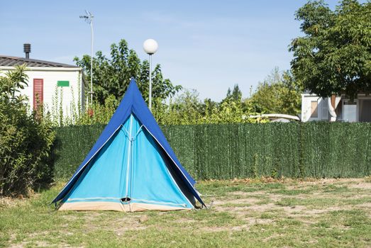 Tents on campsite. Green meadow