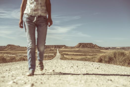 Woman walking on dirt road. Looking like a movie