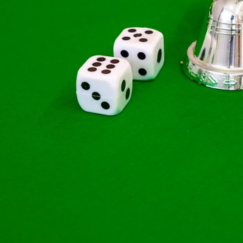 white dice on green cloth or tablecloth