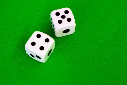 white dice on green cloth or tablecloth