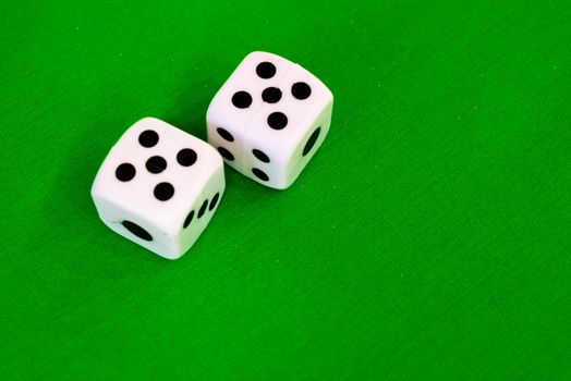 white dice on green cloth or tablecloth