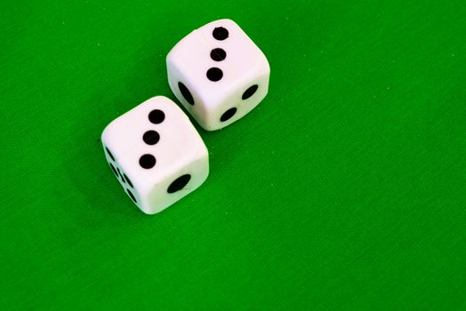 white dice on green cloth or tablecloth