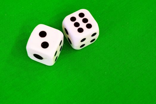 white dice on green cloth or tablecloth