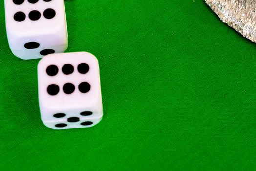 white dice on green cloth or tablecloth