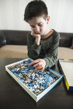 Child and puzzle. Pile puzzles