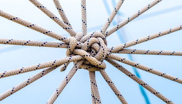 lots of ropes and a big knot against the blue sky