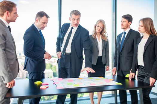 Creative business team discussing working plans using colour sticky notes