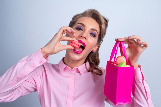 Woman eating macaroons holding pink gift bag