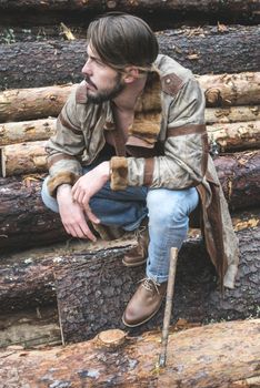 Young men on logs in the forest. Leather and jeans