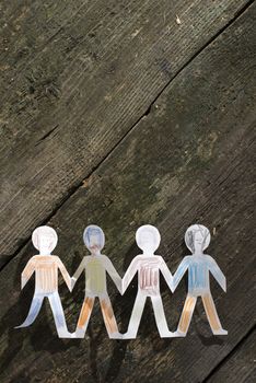 Paper made people figures. Painted white figures on wooden board