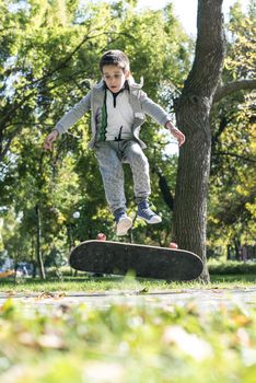 Boy with skateboard in the park. Autumn leaves