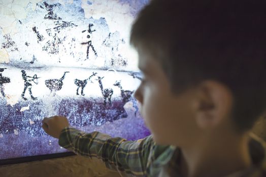  Child looks at aancient mural. Face