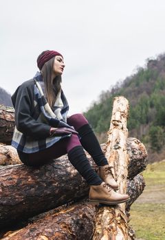 Young woman on wood logs