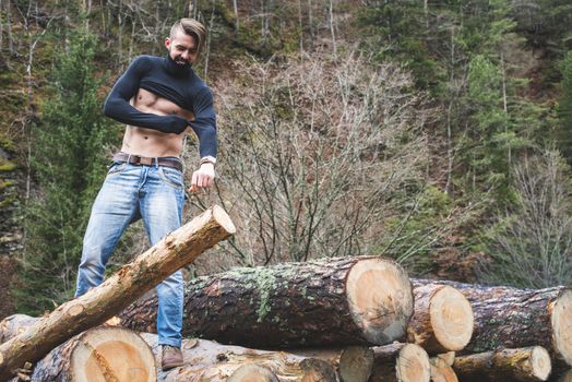 Young men on logs in the forest. Men dress.