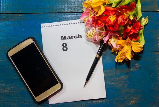 notebook and cell phone with flowers and note with place for text