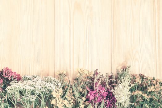 Bundles of medicinal herbs on a light wooden background, alternative medicine and herbal treatment concept, copy space, place for text.