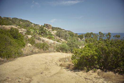 Small mountain dirt path: a path that leads to the sea in the most isolated beaches of the southern coast of Sardinia in Italy.