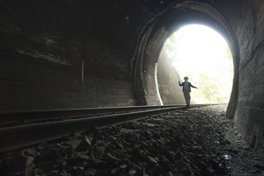 Child walking in railway tunnel. Vintage clothes