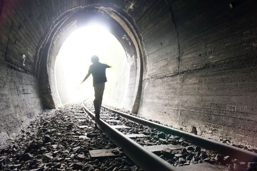 Child walking in railway tunnel. Vintage clothes