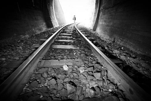 Child walking in railway tunnel. Vintage clothes