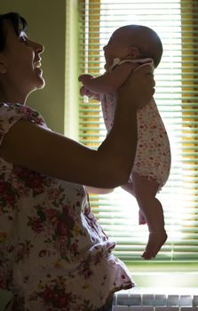 Baby and mom to the window. Backlight