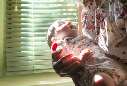 Baby and mom to the window. Backlight