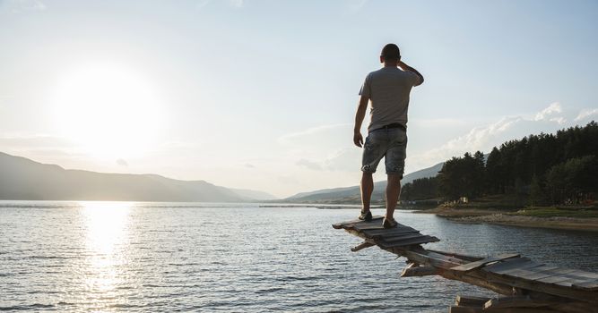 Young adult in front of mountain dam