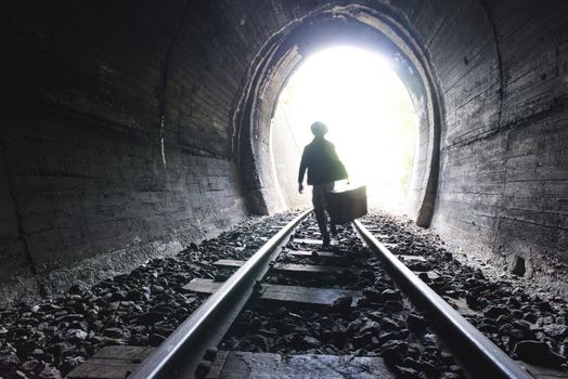 Child walking in railway tunnel. Vintage clothes