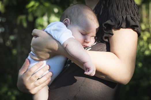 Baby in his mother's arms. Close up