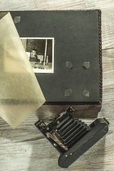 Vintage photo camera and album on white wooden background
