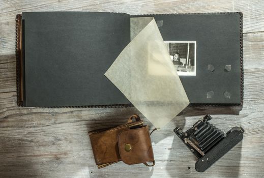 Vintage photo camera and album on white wooden background