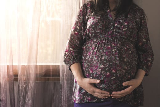 Pregnant women to the window. Violet colors