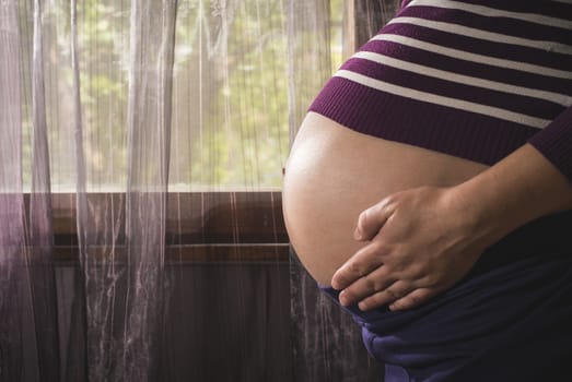 Pregnant women to the window. Violet colors