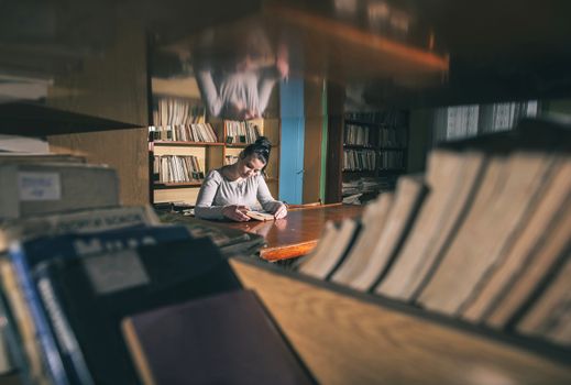 Student girl in a library. Looking at book