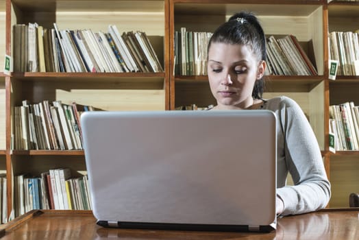 Student girl and laptop in a vintage library