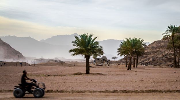 man rides on an ATV on the background of the desert and the mountains of Sharm El Sheikh Egypt