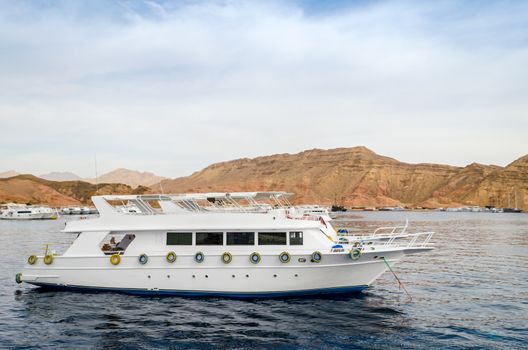 big white boat at sea on the background of the rocky coast in Egypt