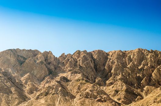 peaks high rocky mountains against a clear blue sky