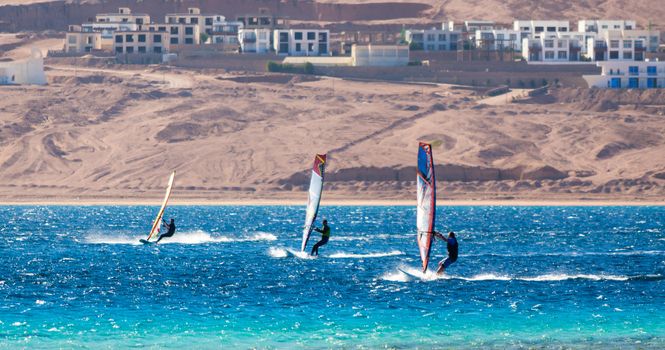 three surfers compete in the Red Sea in the lagoon in Egypt