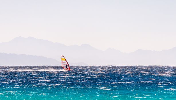 windsurfer rides on a background of high mountains in Egypt Dahab