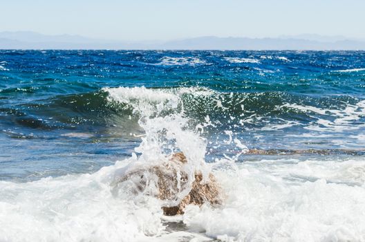waves and splashes of sea surf and stones on the seashore