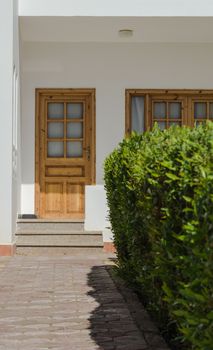 white house with a stone path and a green bush nearby in Egypt Dahab South Sinai