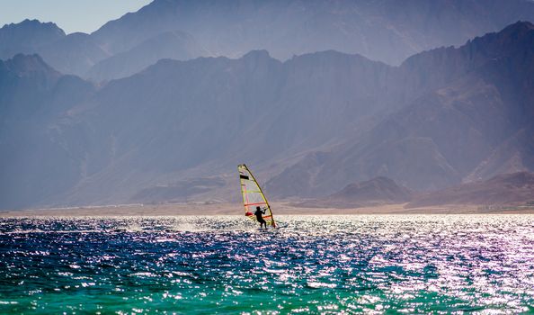 surfer ride in the sea on the background of the rocky coast in Egypt