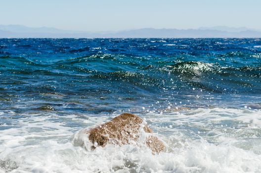 waves and splashes of sea surf and stones on the seashore