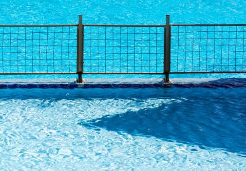 metal fence grill in the pool with blue water