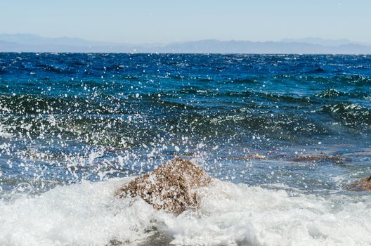 waves and splashes of sea surf and stones on the seashore
