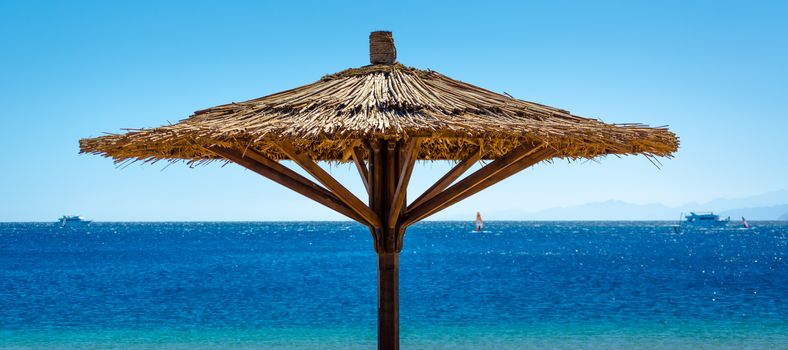 reed beach umbrella against the blue sea in Egypt