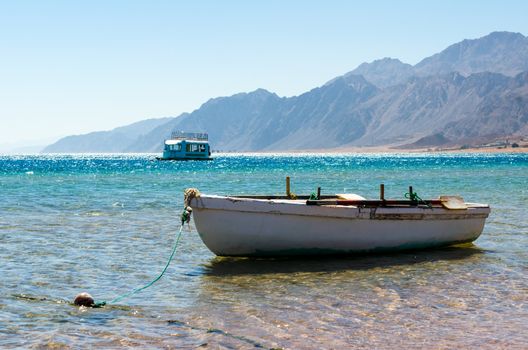 old wooden fishing boat in the sea against the backdrop of the high rocky mountains in Egypt Dahab