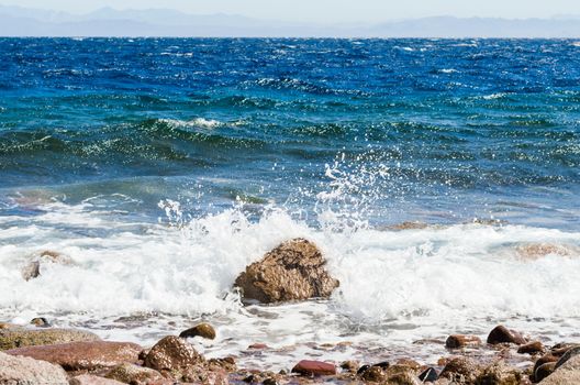 waves and splashes of sea surf and stones on the seashore