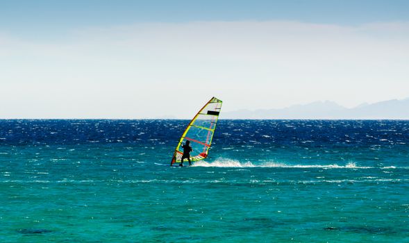 windsurfer on the background of mountains rides on the waves of the Red Sea in Egypt Dahab